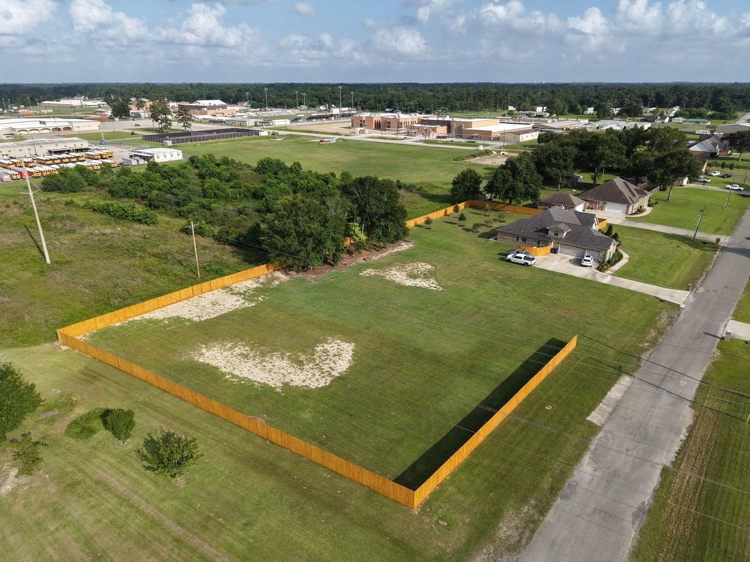 Aerial view of a large wood privacy fence perimeter installed by GoldTex Industries