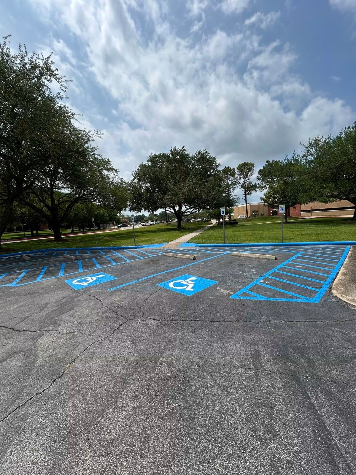 Blue ADA-compliant accessible parking striping at a campus parking lot