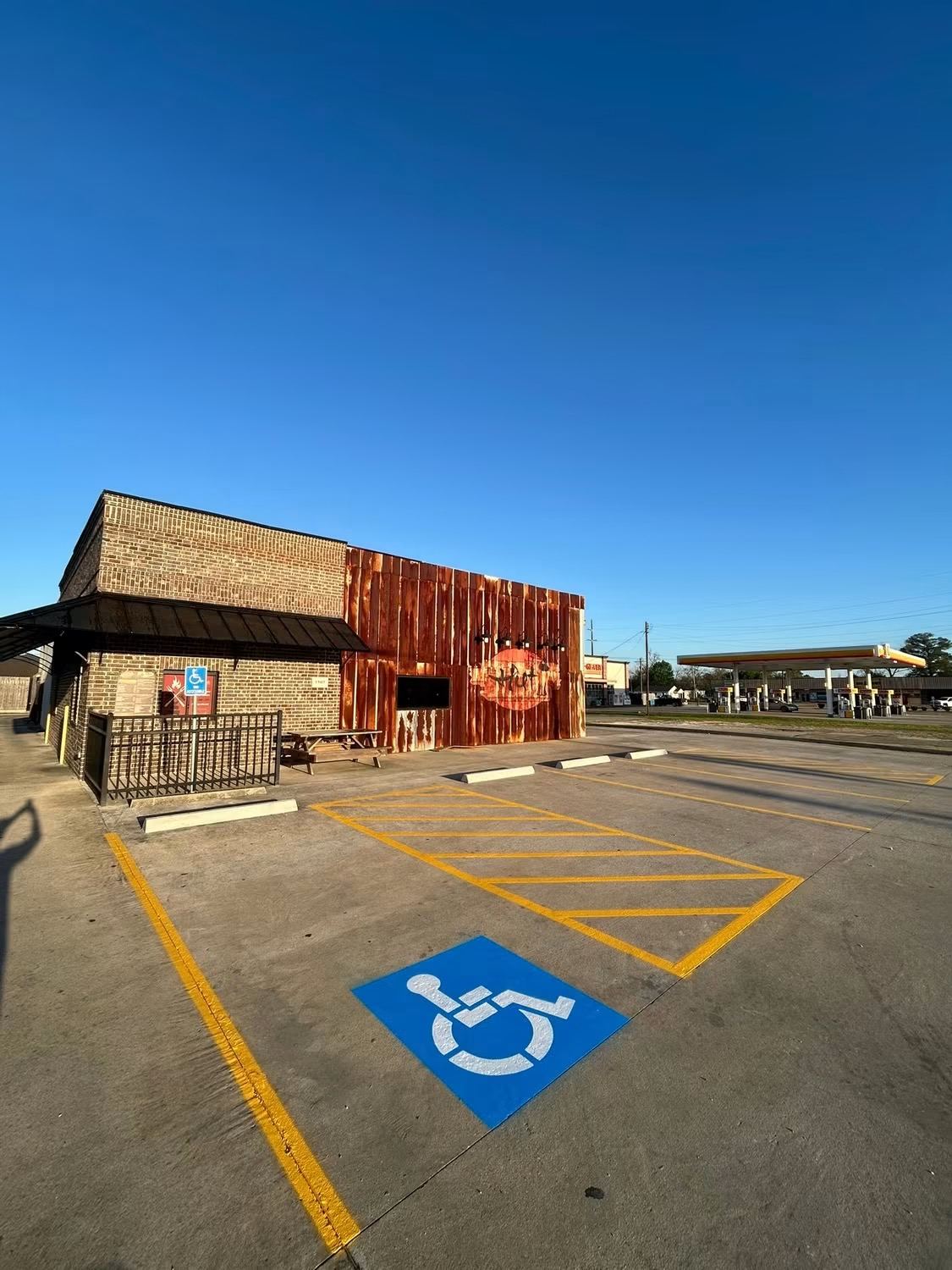 New ADA accessible parking stall and yellow crosshatch striping at a Southeast Texas restaurant